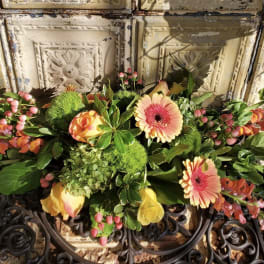 Mixed floral arrangement with pink gerbera daisies and yellow roses