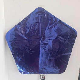 Blue star-shaped foil balloon against a white wall