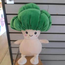 Plush toy with a large green top and cream body displayed on a shelf