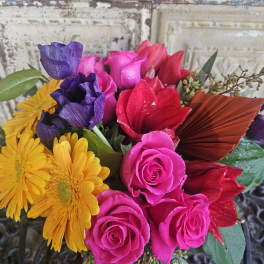 Bouquet of pink roses, purple blooms, and yellow daisies