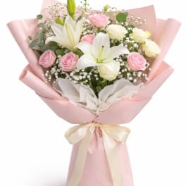 Pink and white bouquet with lilies and roses wrapped in pink paper