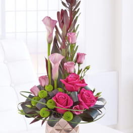 Pink roses and calla lilies in a geometric vase