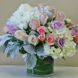 Bouquet of pastel roses and white hydrangeas in a glass vase