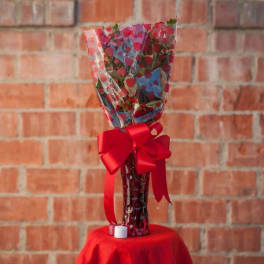 Wrapped bouquet with a red ribbon in a glass vase