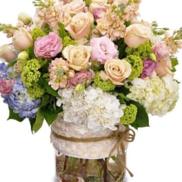 Pastel bouquet of roses and hydrangeas in a clear vase