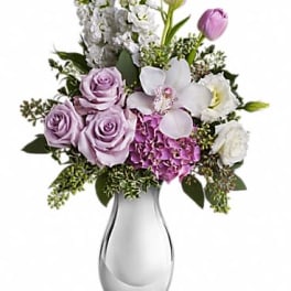 Lavender and white bouquet with roses, tulips, hydrangea, and orchid in a silver vase