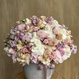 Large pastel bouquet of roses, chrysanthemums, and small pink flowers in a gray vase