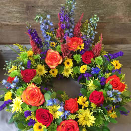 Colorful floral wreath with roses, daisies, and purple spikes