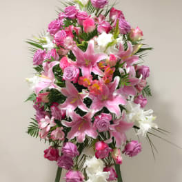 Tall standing floral spray with pink lilies, roses, and white blooms