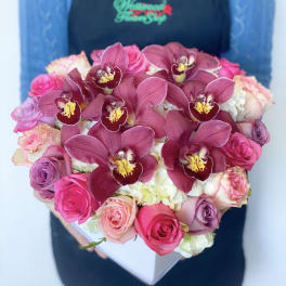Heart-shaped box of pink roses and burgundy orchids