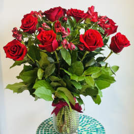 Bouquet of red roses and pink alstroemeria in a glass vase