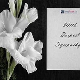 White gladiolus flowers beside a sympathy card