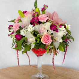 Pink and white floral arrangement in a tall glass vase