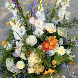 Large mixed floral arrangement with white, purple, and orange blooms