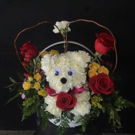 Floral basket with a teddy bear face made of white flowers and red roses