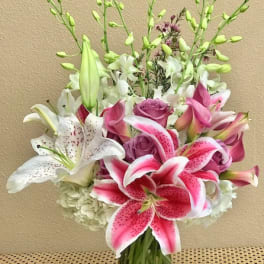 Pink and white lilies with roses in a glass vase