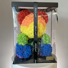 Rainbow teddy bear made of roses in a clear gift box