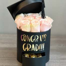 Pink roses in a black graduation box with a tassel