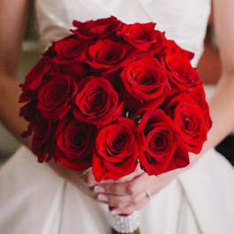 Bride holding a bouquet of red roses
