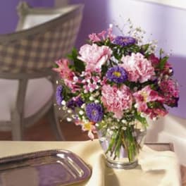 Pink and purple mixed bouquet in a clear glass vase