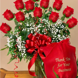 Bouquet of red roses with a red ribbon in a glass vase