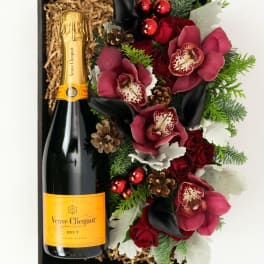 Gift box with a champagne bottle and red floral arrangement