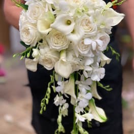 White bridal bouquet with roses, calla lilies, and trailing orchids