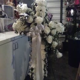 Large white floral standing spray with a satin bow