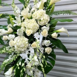 White floral standing spray with roses, lilies, and calla lilies