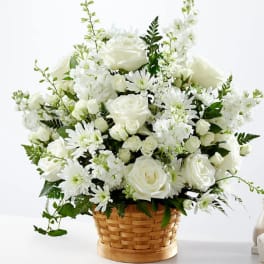 White roses and daisies arranged in a woven basket