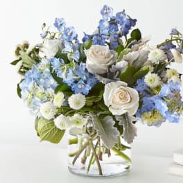 Blue and white flower arrangement in a clear glass vase