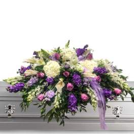 Lavender and white funeral spray on a silver casket