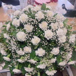 Large white carnation arrangement with baby's breath and greenery