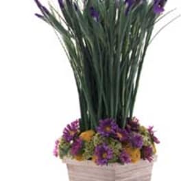 Purple flowers in a square woven basket with tall grass-like stems