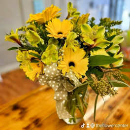 Yellow gerbera bouquet with green alstroemeria in a glass vase