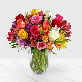 Mixed bouquet of roses and alstroemeria in a clear glass vase