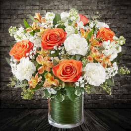 Orange and white mixed bouquet in a glass vase