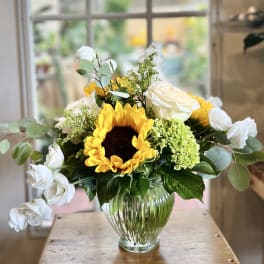 Sunflower and white rose arrangement in a clear glass vase