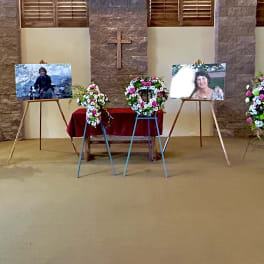 Sympathy floral arrangements on easels and stands in a church