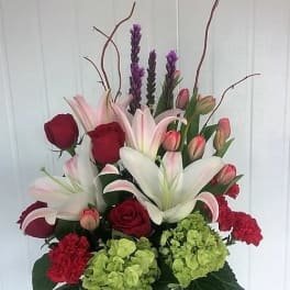 Bouquet of lilies, roses, tulips, and hydrangeas in a vase