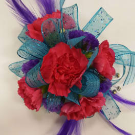 Bright pink carnation corsage with blue ribbon and purple feathers