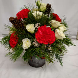 Red and white roses with carnations in a small vase