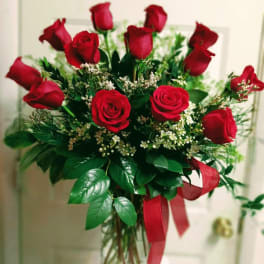 Bouquet of red roses in a clear glass vase with a red ribbon