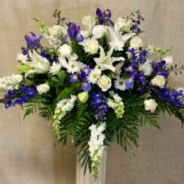 White and purple floral arrangement in a tall vase