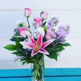 Pink lilies and roses in a clear glass vase