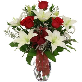 Bouquet of red roses and white lilies in a glass vase