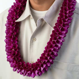 Purple orchid lei worn around the neck over a light button-up shirt