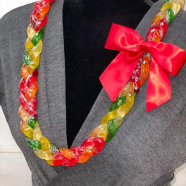 Colorful twisted candy lei necklace with red bow displayed on a gray dress form