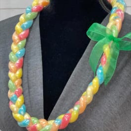 Braided multi-color candy lei with green ribbon bow displayed on a black mannequin