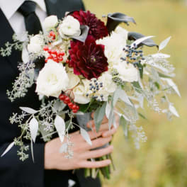 Bride holding a bouquet of white and burgundy flowers